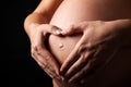 Pregnant woman with hands on her stomach in the form of heart Royalty Free Stock Photo