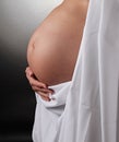Pregnant woman with hands on her tummy stroking her baby with people stock photo Royalty Free Stock Photo