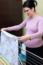 Pregnant woman hanging washing