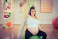 Pregnant woman having relaxing massage while sitting on exercise ball Royalty Free Stock Photo