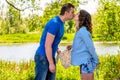 Pregnant woman and her husband kiss in the park