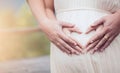 Pregnant woman and her husband making hand heart shape together