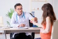 The pregnant woman with her husband visiting the doctor in clinic Royalty Free Stock Photo