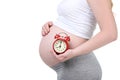 Pregnant woman holding alarm clock