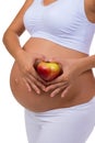 Pregnant woman holding an apple. Vitamins and healthy food during pregnancy