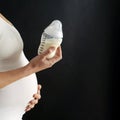 Pregnant woman holding a baby bottle. Conceptual image shot Royalty Free Stock Photo