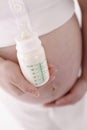 Pregnant woman holding baby bottle with milk Royalty Free Stock Photo