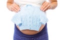 Pregnant woman holding baby clothes Royalty Free Stock Photo