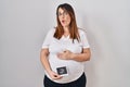 Pregnant woman holding baby ecography making fish face with mouth and squinting eyes, crazy and comical