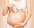 Pregnant woman holding baby shoes Royalty Free Stock Photo