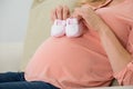 Pregnant Woman Holding Baby Shoes On Sofa Royalty Free Stock Photo