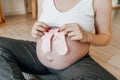 Pregnant woman holding baby socks, copy space. Royalty Free Stock Photo