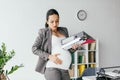 Woman holding belly, enduring pain and holding folders Royalty Free Stock Photo