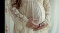 Pregnant woman holding belly in a lace dress.