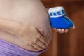 Pregnant woman holding blue baby booties on belly, closeup Royalty Free Stock Photo