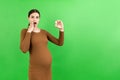 Pregnant woman holding a bottle of pills against her belly at colorful background with copy space. Taking medication during Royalty Free Stock Photo