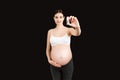 Pregnant woman holding a bottle of pills against her belly at colorful background with copy space. Taking medication during Royalty Free Stock Photo