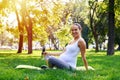 Pregnant woman holding bottle of water, sitting on yoga mat in p Royalty Free Stock Photo