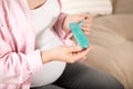 Pregnant woman holding box with pills indoors, closeup Royalty Free Stock Photo