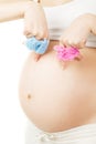 Pregnant woman holding boy and girl clothes Royalty Free Stock Photo