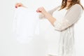 Pregnant woman holding clothes for newborns on white background,blank,copy space,happy event,birth of a child Royalty Free Stock Photo