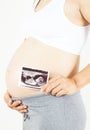 Pregnant woman holding the digital echography photograph of her