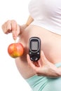 Pregnant woman with glucometer and apple, diabetes and healthy nutrition during pregnancy Royalty Free Stock Photo