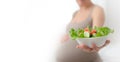 Pregnant woman is holding fresh vegetables in her hand. Concept of healthy eating during pregnancy. Royalty Free Stock Photo