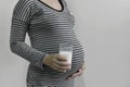 Pregnant woman holding glass water and hand touching belly Royalty Free Stock Photo