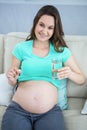 Pregnant woman holding glass of water and pills Royalty Free Stock Photo