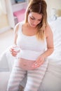 Pregnant woman holding glass of water and pills Royalty Free Stock Photo