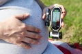 Pregnant woman holding glucometer in hand and her belly in other. Diabetes test Royalty Free Stock Photo