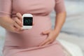 Pregnant woman holding glucose meter with result of measurement sugar high level. gestational diabetes concept