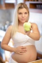 Pregnant woman holding green Apple and smiling Royalty Free Stock Photo