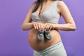 Baby booties for unborn child on the belly of pregnant woman Royalty Free Stock Photo