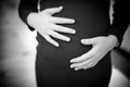 pregnant woman holding hands on her baby bump Royalty Free Stock Photo