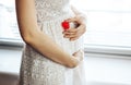 Plastic heart at pregnant belly Royalty Free Stock Photo