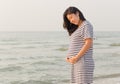 Pregnant woman holding her belly on the beach with copy space. Royalty Free Stock Photo