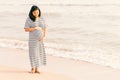 Pregnant woman holding her belly on the beach with copy space in Royalty Free Stock Photo