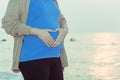 Pregnant woman holding her belly on the beach with copy space in Royalty Free Stock Photo