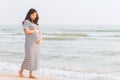 Pregnant woman holding her belly on the beach. Royalty Free Stock Photo