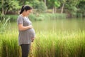 Pregnant woman holding her belly in the green gardent. Royalty Free Stock Photo