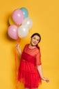Pregnant woman holding multicolored festive balloons