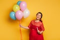 Pregnant woman holding multicolored festive balloons