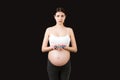 Pregnant woman holding a pile of blisters of pills at colorful background with copy space. Vitamins during pregnancy concept Royalty Free Stock Photo