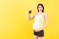 Pregnant woman holding a pile of blisters of pills at colorful background with copy space. Vitamins during pregnancy concept Royalty Free Stock Photo