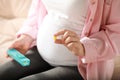 Pregnant woman holding pill on blurred background closeup Royalty Free Stock Photo