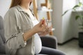 Pregnant woman holding pill and glass with water at home, closeup Royalty Free Stock Photo