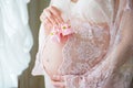 Pregnant woman holding pink baby shoes on her belly Royalty Free Stock Photo