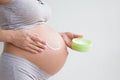 Pregnant woman holding red heart and hand on her belly, symbol of new life, concept of expecting for baby and extending family Royalty Free Stock Photo